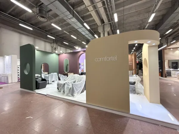 Volumi adiacenti in verde, crema e malva — un solo sistema, quattro stand diversi. · Pan.door.a